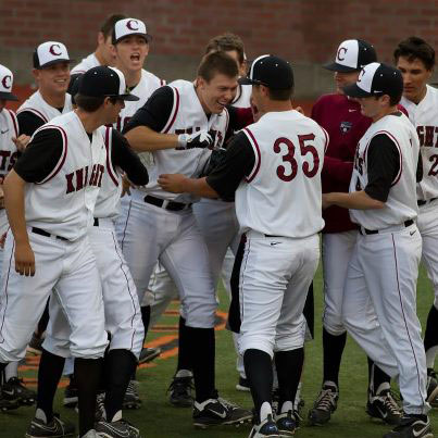 Austin Barr (19) is mobbed by teammates after his grand slam against Wenatchee