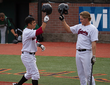 Marc Gallegos of Corban and Portland's Kevin Farley celebrate Marc's homer
